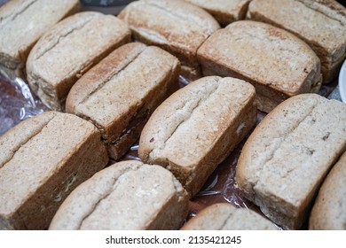 Pile Of Loaf Toast Bread Freshly Baked On Table At The Kitchen. Many Traditional Fresh Round And Square Bread Loaves For Sale. No People. Selective Focus.