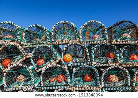 A pile of lobster pots stacked near the coast of Benbecula in the Western Isles, with a blue sky overhead