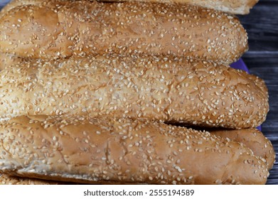 Pile of long sesame buns bread, a fresh baked loaf of bread French Fino ready to fillings, usually filled with savory fillings, made from a dough of flour, milk, yeast and butter - Powered by Shutterstock