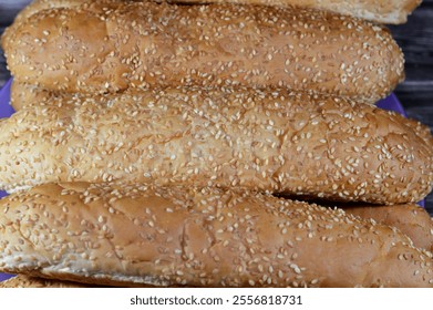 Pile of long sesame buns bread, a fresh baked loaf of bread French Fino ready to fillings, usually filled with savory fillings, made from a dough of flour, milk, yeast and butter - Powered by Shutterstock