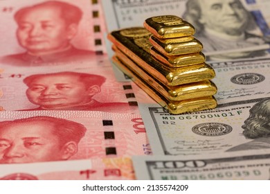 Pile Of Long And Short Pure Gold Bars, Bullion, Ingot On Background Of Renminbi, Or RMB, CNY, Currency Of China And US Dollar Banknotes