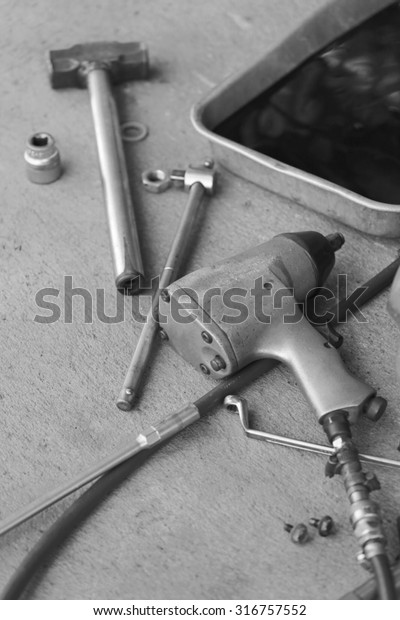 Pile maintenance tool in a car repair,Style color\
of black and white.