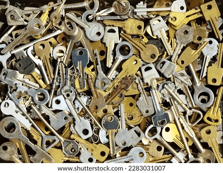 Pile of many different yellow and white old metal keys choice to open a door. Vintage close-up background