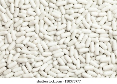 Pile of many white drug pills laying in a pile