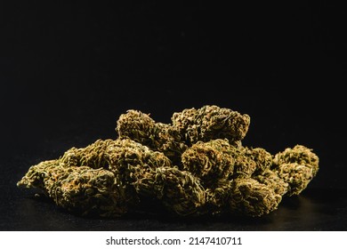 Pile of marijuana buds on a black background.