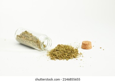 pile of marijuana with open glass jar and cork stopper, white background