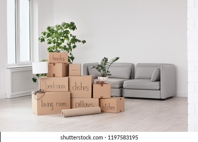 Pile Of Moving Boxes And Household Stuff In Living Room