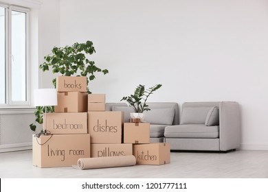 Pile of moving boxes and household stuff in living room