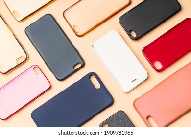Pile of multicolored plastic back covers for mobile phone. Choice of smart phone protector accessories on neutral background. A lot of silicone phone backs or skins next to each other