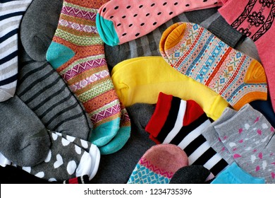 A Pile Of Multi-colored Socks. View From Above. Many Colorful Socks Form A Textural Background. Socks Of Different Types And Sizes.