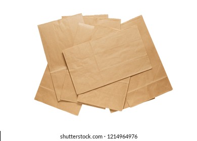 Pile Of New Kraft Paper Bags Laying Flat  Isolated On White Background .
Brown Paper Bags With Clipping Path .