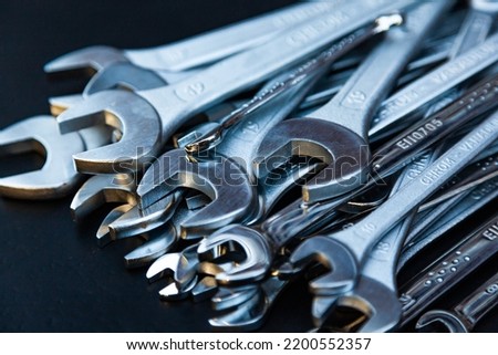 Pile of new wrenches on a black background, close-up.