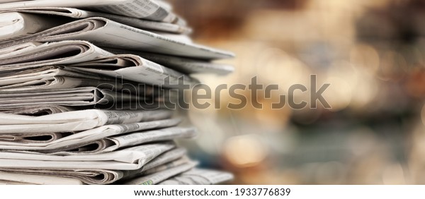 Pile of\
newspapers stacks on blur\
background
