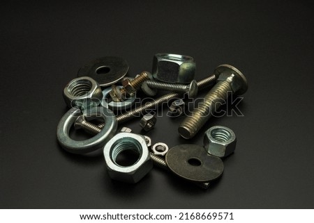 A pile of nuts bolts and washers on a black background