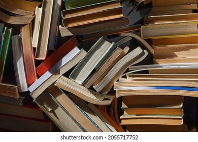 Pile Of Old Books In Dramatic Dim Light In The Attic, Forming Book Wall, Messy Arrangement