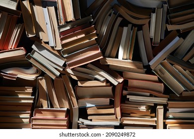 Pile Of Old Books In Dramatic Dim Light In The Attic, Forming Book Wall, Messy Arrangement