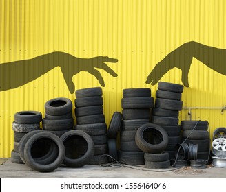 pile of old car tires against the yellow wall of tire service, concept of change old tyres or for new season, shadow of hands choose tyres, copy space 