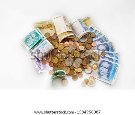 Pile of old, partly rusty coins as well as banknotes of the former German currency Deutsche Mark that is not in use anymore, isolated on white background - the value is over 1000 D-Mark
