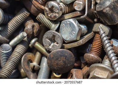 A pile of old rusty bolts, nails and staples.