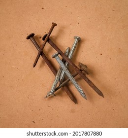 a pile of old rusty nail with brown wood background