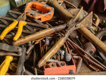 A Pile Of Old Rusty Tools Scattered On The Workbench Table