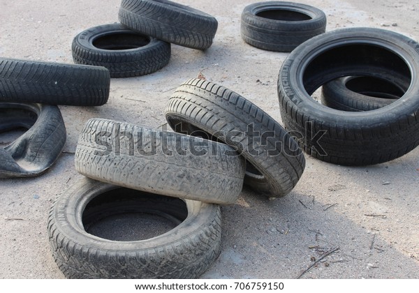 A pile of old tires on\
asphalt