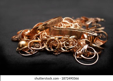 Pile Of Old Used Scrap Gold Jewelry On Black Background.