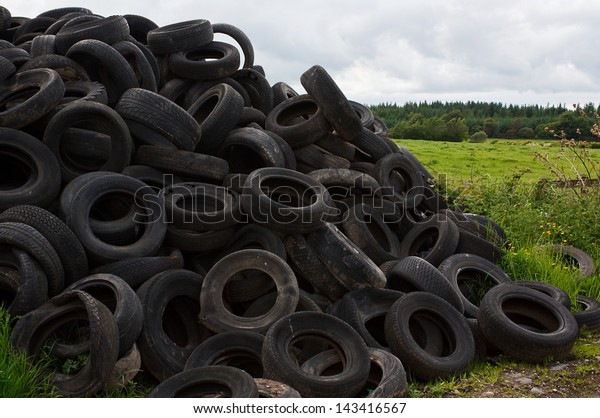 Pile of old vehicle tires dumped in the\
countryside by farmer