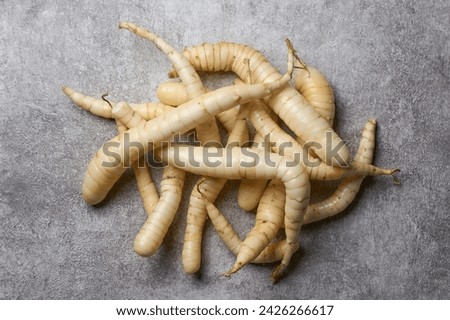 pile of organic arrowroot rhizomes, maranta arundinacea, tropical plant known for starchy rhizomes harvested for various culinary purposes, used as gluten free alternative, on textured table top