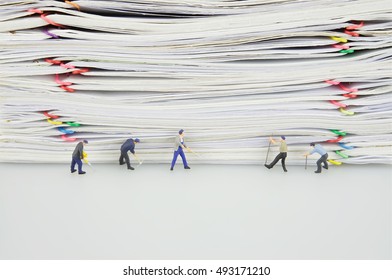 Pile Overload Paper With Colorful Paperclip And Miniature People Are Destroyed It On White Background.