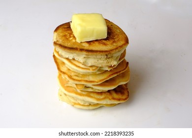 Pile Of Pancakes Isolated On White With Yellow Pat Of Butter On Top. High Side Angle