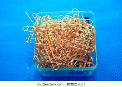 Pile Of Paper Clips On Blue Background