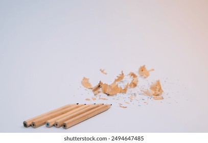 A pile of pencil shavings sits on a white background. The pencil - Powered by Shutterstock