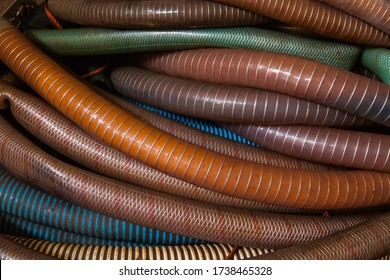 A pile of plastic hoses with a metal braid inside, close up.