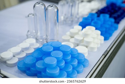 Pile of plastic screw caps. Caps packaging concept. Bottle caps and closures packaging design. Cap products. Bottle cap and blur PET plastic bottle preforms before blow molding. Packaging industry.  - Powered by Shutterstock