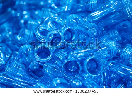The pile of preform shape from injection process, PET bottles in the container box. The plastic drinking water bottle manufacturing process in the plant.