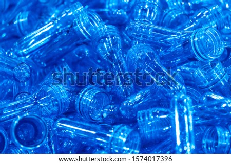 The pile of preform shape from injection process, PET bottles in the container box. The plastic drinking water bottle manufacturing process in the plant.