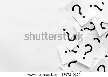 Pile of question marks printed on white cards forming a side border over a white background with copy space in a conceptual image