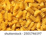 Pile of raw fusilli pasta close-up. Italian pasta, pasta cones texture, top view