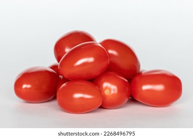 Pile of red small cherry tomatoes on white background, close up - Powered by Shutterstock