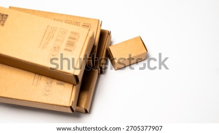 A Pile of Retail Packaging Boxes Featuring Standard Delivery and Recycling Markings.