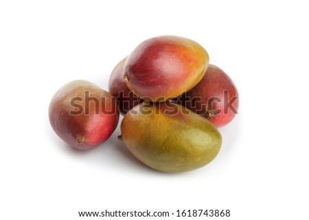 a pile  of ripe natural looking Palmer mangoes on a white table top