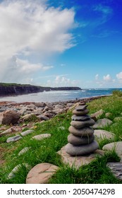 Pile Of Rocks Stack On Each Over In Nature Environment. Warm Sunny Day, Cloudy Sky. Balance, Patience And Zen Concept