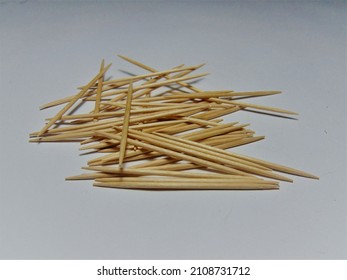 pile of round wooden toothpicks on white background