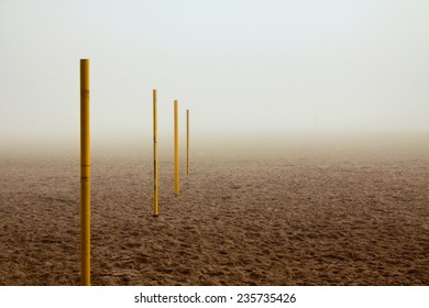 Pile Row In Sand On Foggy Beach