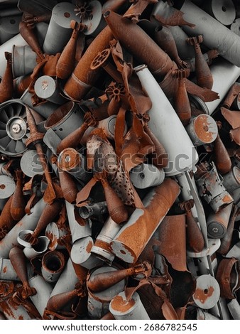 Pile of rusty mortar shells and rocket parts - close-up view. Ordnance texture background.