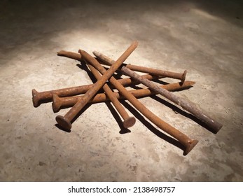 pile of rusty nails lying on the floor in the sun