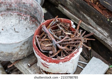a pile of rusty nails in an old plastic bucket. close-up