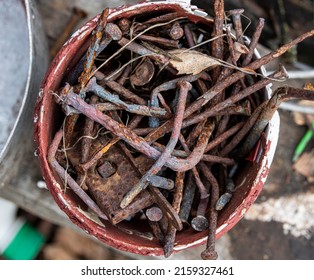 a pile of rusty nails in an old plastic bucket. flatlay