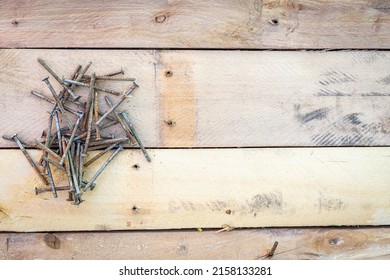 A pile of rusty nails on several pieces of wood with a space for copy